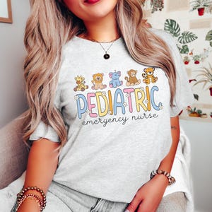 May include: A gray t-shirt with a colorful graphic of cartoon animals and the text "PEDIATRIC emergency nurse".