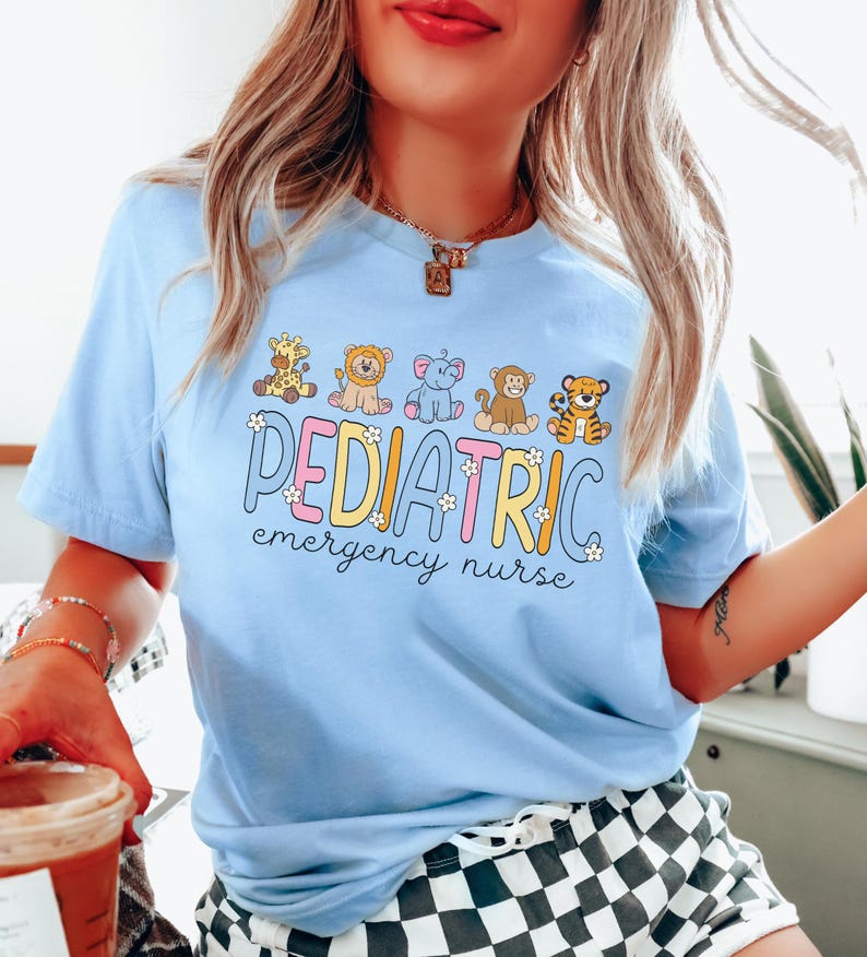 May include: A light blue t-shirt with a graphic of a line of cartoon animals and the text "PEDIATRIC emergency nurse".
