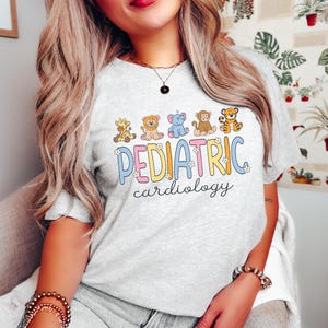 May include: A grey t-shirt with a colourful graphic of animals and the text "PEDIATRIC cardiology".