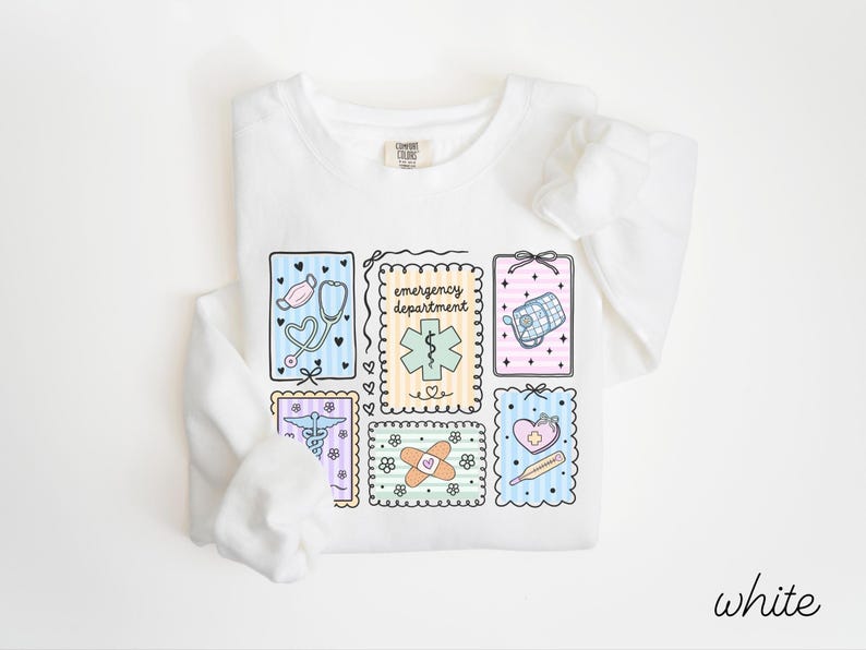 Pode incluir: Camisola branca de manga comprida com um design de tema m&eacute;dico. O design inclui um estetosc&oacute;pio, uma mala m&eacute;dica e outros s&iacute;mbolos m&eacute;dicos. As palavras "emergency department" tamb&eacute;m est&atilde;o inclu&iacute;das.