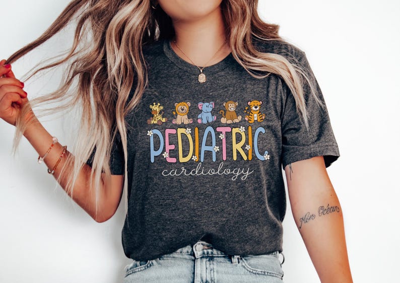 May include: A dark grey t-shirt with a colourful graphic that says "PEDIATRIC cardiology" with cartoon animals. The animals are a giraffe, a lion, an elephant, a monkey, and a tiger.