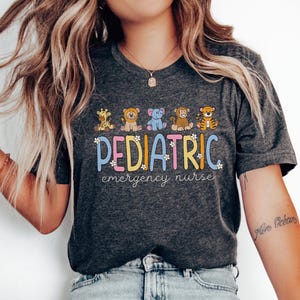May include: A dark gray t-shirt with a colorful graphic of animals and the text "PEDIATRIC emergency nurse".