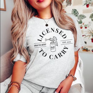 Spray Tan Artist Shirt • Licensed To Carry Spray Tan Artist Work Tshirt • Personalized Spray Tan Tech EST. 2025 Gift • Sunless Tanning Salon Ash