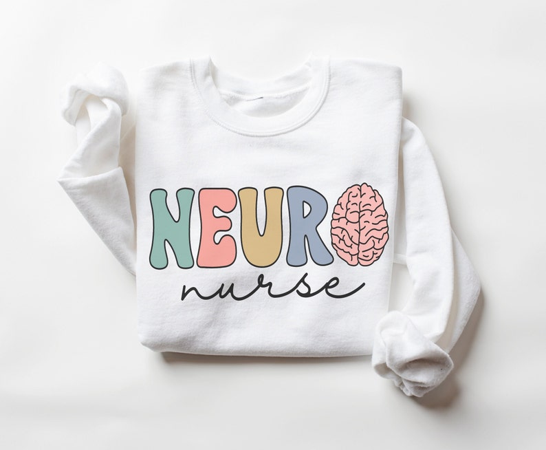 Puede incluir: Sudadera blanca con el texto "NEURO nurse" en letras de colores y un gr&aacute;fico de cerebro rosa.