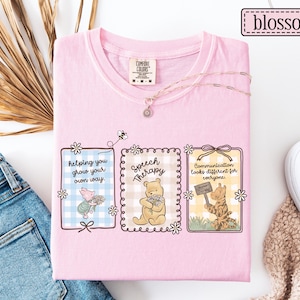 May include: Pink Comfort Colors t-shirt featuring three framed illustrations with Winnie the Pooh characters and text. The text includes "helping you grow your own way," "Speech Therapy," and "Communication looks different for everyone."