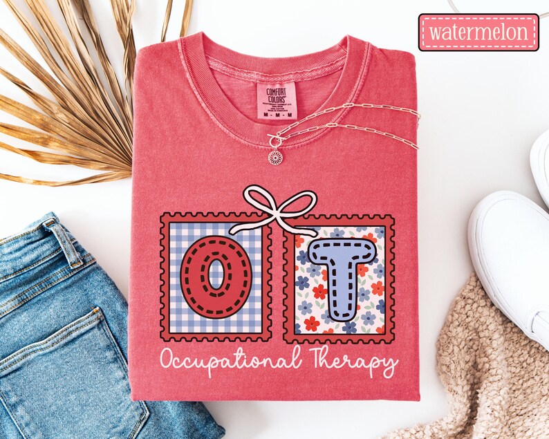 May include: A watermelon-colored t-shirt with the letters "OT" in a postage stamp design. The "O" is red with a blue and white gingham background, and the "T" is blue with a floral background. The words "Occupational Therapy" are written below.