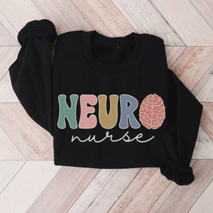 Puede incluir: Sudadera negra con el texto "NEURO nurse" en letras de colores y un gr&aacute;fico de cerebro.