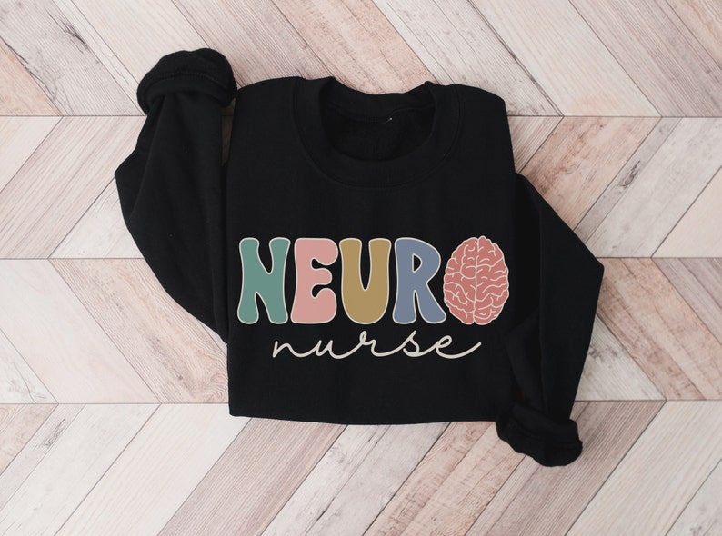 Puede incluir: Sudadera negra con el texto "NEURO nurse" en letras de colores y un gr&aacute;fico de cerebro.