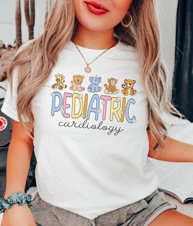 May include: White t-shirt with a colourful graphic that says "PEDIATRIC cardiology" with cartoon animals. The animals are a giraffe, lion, elephant, monkey, and tiger.