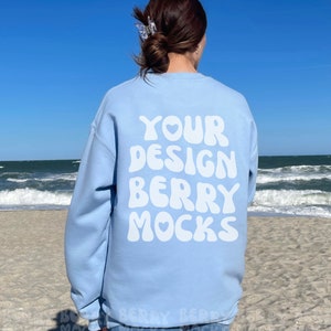 May include: A light blue sweatshirt with the text "YOUR DESIGN BERRY MOCKS" printed on the back in white bubble letters.