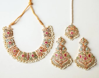 May include: A gold necklace and earrings set with a floral design. The jewelry is adorned with colorful gemstones and pearls.