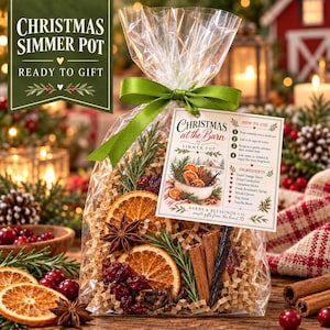 May include: A clear plastic bag filled with dried orange slices, cinnamon sticks, star anise, cranberries, and rosemary sprigs. A green ribbon ties the top. A tag reads Christmas at the Barn Simmer Pot with instructions and ingredients listed.
