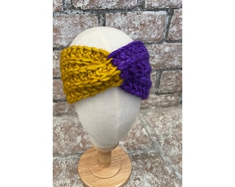 May include: A yellow and purple crocheted headband. The headband is twisted and has a knot in the center.