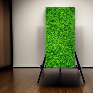 May include: A green canvas print of a clover pattern on a black easel.