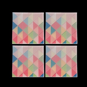 Puede incluir: Conjunto de cuatro posavasos coloridos con un patrón geométrico de triángulos rosas, azules, verdes y amarillos.