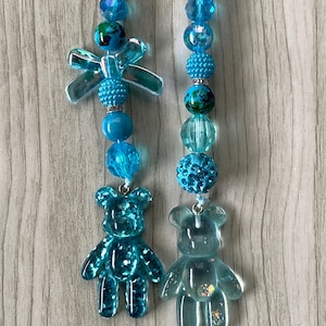 Könnte beinhalten: Eine weiße Keramiktasse mit schwarzem Henkel und dem Text "But First, Coffee" in schwarzer, handschriftlicher Schrift. Die Tasse steht auf einer weißen Oberfläche.