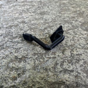 Peut inclure: Une pièce de voiture en plastique noir avec une forme incurvée.