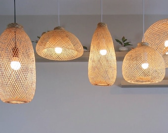 May include: A gray sectional sofa with multiple pillows sits in a living room with a white rug. The room is decorated with several woven pendant lights hanging from the ceiling.
