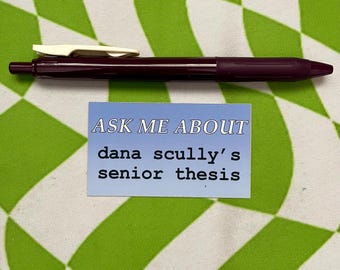 May include: A blue and white sticker with the text "ASK ME ABOUT dana scully's senior thesis" on a green and white checkered background.