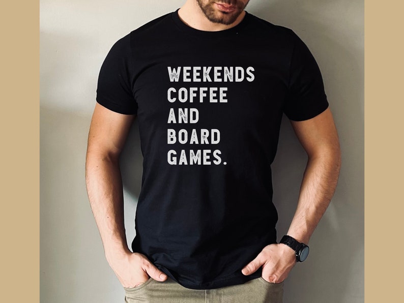 May include: A black t-shirt with white text that reads "Weekends Coffee and Board Games."