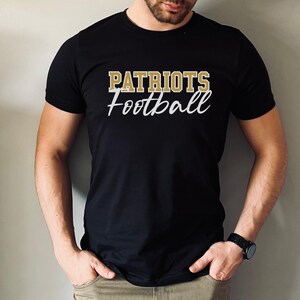 May include: A black t-shirt with the text "PATRIOTS Football" in gold lettering.