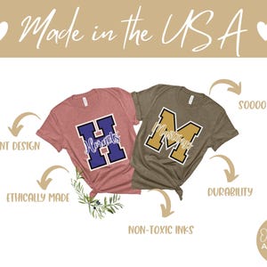 Puede incluir: Dos camisetas con diferentes logotipos de escuela. La camiseta rosa tiene una "H" morada con la palabra "Hornets" escrita en su interior. La camiseta marr&oacute;n tiene una "M" dorada con la palabra "Mustangs" escrita en su interior. Las camisetas est&aacute;n hechas en los Estados Unidos y est&aacute;n hechas &eacute;ticamente con tintas no t&oacute;xicas.