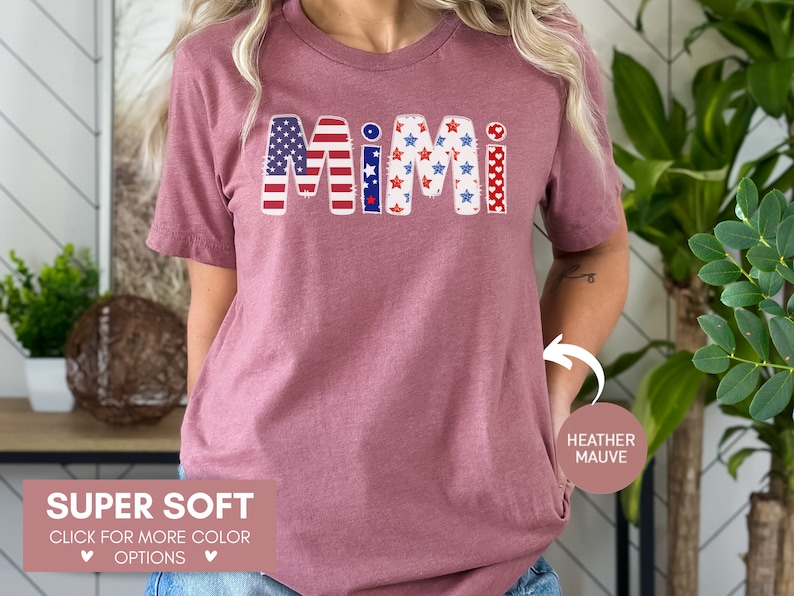 K&ouml;nnte beinhalten: Ein T-Shirt in Heide-Mauve mit dem Wort "MIMI" in den patriotischen Farben Rot, Wei&szlig; und Blau. Die Buchstaben sind mit Sternen und Streifen verziert. Das Shirt ist superweich und in anderen Farben erh&auml;ltlich.