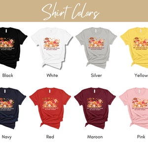 Op de afbeelding: Een mockup van een T-shirt met de tekst "We will literally feast on your corpse" en een afbeelding van paddenstoelen. Het shirt is verkrijgbaar in 10 kleuren: zwart, wit, zilver, geel, marineblauw, rood, bordeauxrood, roze, grijs melange en donker grijs melange.