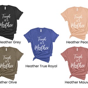 K&ouml;nnte beinhalten: F&uuml;nf T-Shirts in verschiedenen Farben mit dem Aufdruck "Tough as a Mother" in Wei&szlig; auf der Vorderseite. Die Shirts sind in den Farben Dunkelgrau meliert, Pfirsich meliert, K&ouml;nigsblau meliert, Oliv meliert und Mauve meliert.