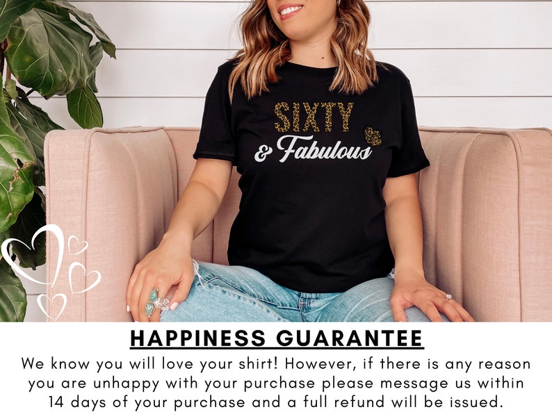 May include: Black t-shirt with gold glitter text that reads "SIXTY & Fabulous". The shirt is being worn by a person sitting on a pink couch. The text "HAPPINESS GUARANTEE" is at the bottom of the image.