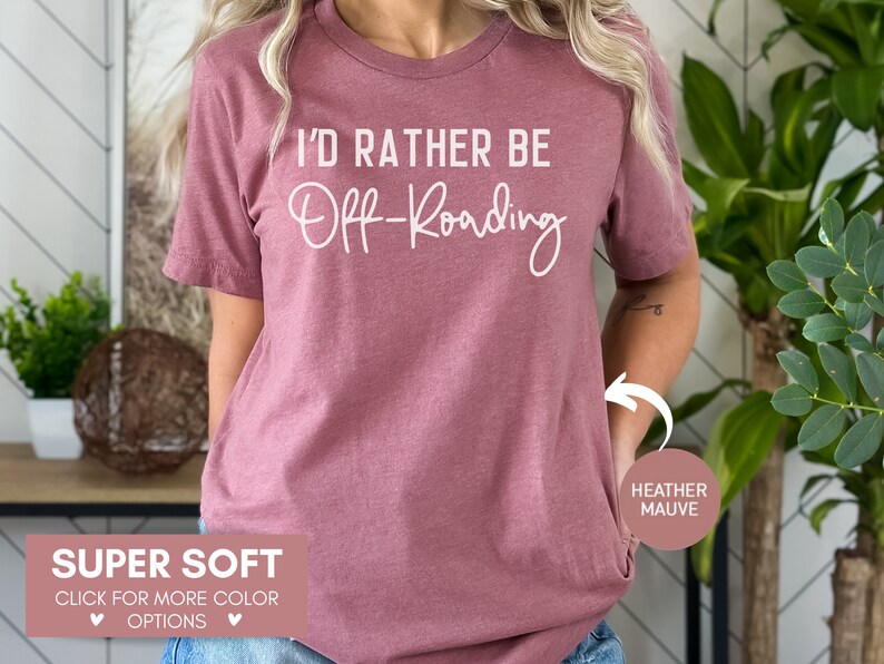 May include: A heather mauve t-shirt with the text "I'D RATHER BE Off-Roading" in white. The shirt is super soft and available in other colors.