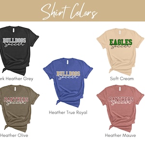 May include: Five different color t-shirts with the words "Bulldogs Soccer", "Eagles Soccer", and "Panthers Soccer" printed on them. The shirts are in the colors dark heather grey, soft cream, heather true royal, heather olive, and heather mauve.