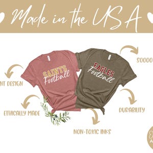 May include: Two t-shirts, one pink with "Saints Football" and one brown with "Eagles Football" in white text. The shirts are laid out on a white background with text around them describing the product features: "Vibrant Design", "Ethically Made", "Non-Toxic Inks", "Soooo Soft!" and "Durability".