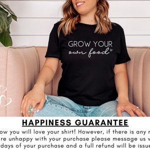 May include: A woman wearing a black t-shirt with the text "GROW YOUR own food" in white lettering. She is sitting on a pink couch. The text "HAPPINESS GUARANTEE" is at the bottom of the image.