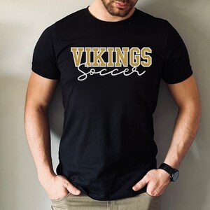 May include: Black t-shirt with gold text that reads "VIKINGS soccer"