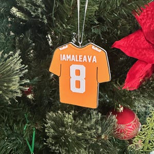 Puede incluir: Adorno de camiseta de f&uacute;tbol naranja y blanca con el nombre "IAMALEAVA" y el n&uacute;mero "8" en la espalda.