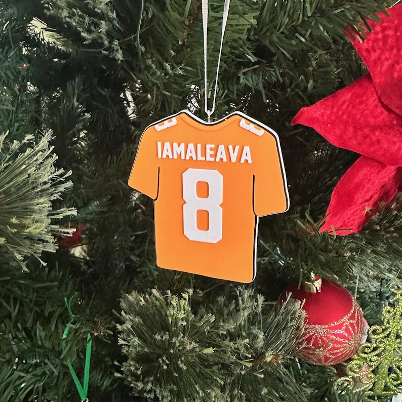 Puede incluir: Adorno de camiseta de f&uacute;tbol naranja y blanca con el nombre "IAMALEAVA" y el n&uacute;mero "8" en la espalda.