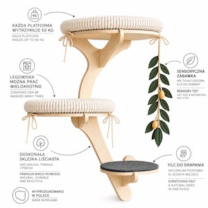 May include: A wall-mounted cat tree made of light-colored birch plywood with three tiered platforms. Two platforms feature round, cream-colored textured cushions with tie-fasteners, while the lowest platform has a dark gray felt pad. A hanging green leaf toy with yellow accents is attached to the top tier.