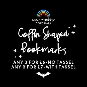 May include: Black background with the text "NEON rainbow GOES DARK" and "Coffin Shaped Bookmarks". The image also includes a neon rainbow, stars, and a bat silhouette. Text states "ANY 3 FOR £6-NO TASSEL" and "ANY 3 FOR £7-WITH TASSEL".