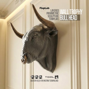 Pode incluir: Um modelo de escultura paramétrica em camadas de um troféu de parede com cabeça de touro. A cabeça de touro é cinza com chifres marrons e um anel de nariz dourado. O texto "WALL TROPHY BULL HEAD" é visível.