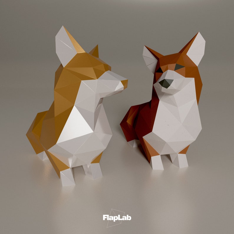 Op de afbeelding: Twee origami-papiercorgi's, een is goud en wit, de andere is bruin en wit. De honden zitten op een lichtgrijze ondergrond.