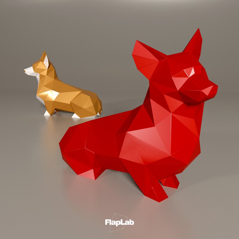 Op de afbeelding: Twee origami-papierhondmodellen, een rood en een gouden, met witte accenten. De rode hond is groter en zit, terwijl de gouden hond erachter staat. De honden zijn gemaakt van gevouwen papier en hebben een geometrisch, veelhoekig ontwerp.