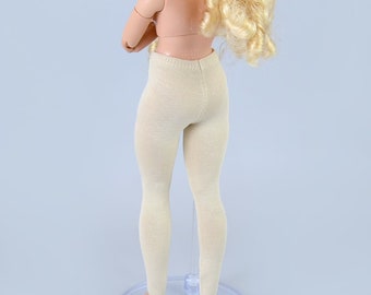 May include: Beige tights for a doll, shown on a doll stand. The tights are made of a soft, stretchy fabric and have a subtle sheen.