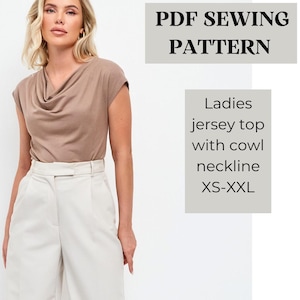 May include: A woman wearing a taupe jersey top with a cowl neckline and cream-coloured trousers. The image includes text that reads "PDF SEWING PATTERN" and "Ladies jersey top with cowl neckline XS-XXL."