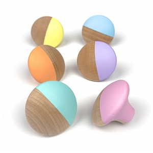 Op de afbeelding: Zes houten knoppen met een halfronde vorm. Elke knop is in een andere pastelkleur geverfd: geel, oranje, lichtblauw, lavendel, roze en turquoise.