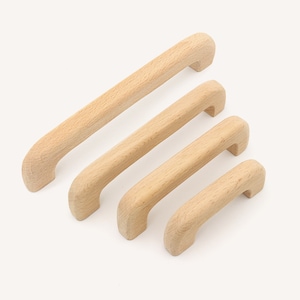 Peut inclure: Quatre boutons de porte en bois de différentes tailles, tous avec un design simple et arrondi.