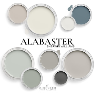 May include: Alabaster paint color palette by Sherwin Williams. The palette includes shades of gray, beige, and white. The paint colors are displayed in small paint can containers.