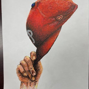 May include: A hand holding a red baseball cap with a blue and white logo. The cap has a white brim and a white stitching detail.