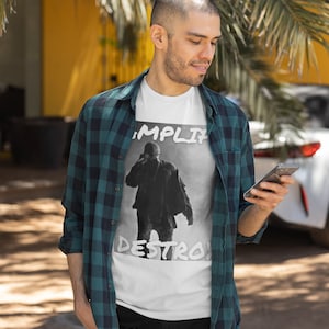 May include: A white t-shirt with a black and white graphic of a person with the text "Amplify Destroy" printed on the front.