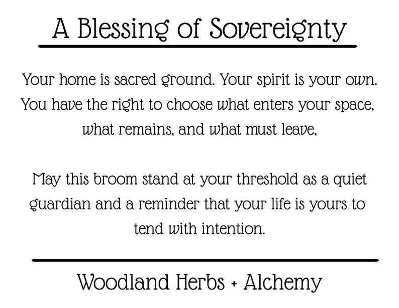 May include: A white rectangular card featuring black text that reads: A Blessing of Sovereignty. Your home is sacred ground. Your spirit is your own. You have the right to choose what enters your space, what remains, and what must leave. May this broom stand at your threshold as a quiet guardian and a reminder that your life is yours to tend with intention. Woodland Herbs + Alchemy.